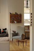 Cat on grey armchair, standard lamp and side table in period apartment