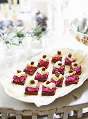 Pumpernickel bread topped with beetroot and soft cheese for New Year's Eve