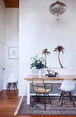 Table and two chairs on white wall