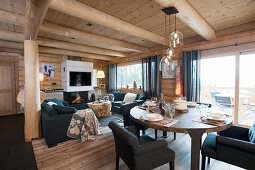Modern furniture in living and dining room of log cabin