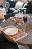 Cutlery with horn handles on place mats on round, rustic wooden table