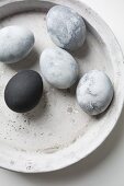 Easter eggs painted with stone effects in concrete bowl