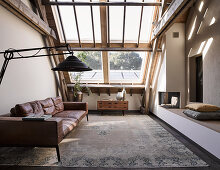 Ledercouch und gemauerte Sitzbank im Wohnzimmer mit Dachflächenfenster