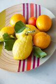 Citrus fruits on bamboo dish with colourful stripes