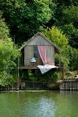 Rustikale Fischerhütte mit romantischem Schlafplatz auf Holzterrasse am See