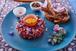 Beef tartare served with toasted bread and oyster plant flowers
