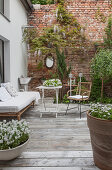 Gemütliche Terrasse vor dem Haus und einer Backsteinmauer