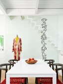 White dining table, chairs, tailors' dummy and pattern of stickers on glass partition