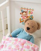 Knitted teddy bear in white retro dolls' bed