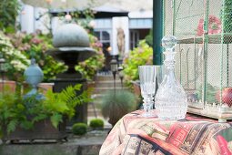 Cut-glass carafe and glasses on table in garden