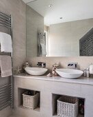 Twin countertop sinks on masonry washstand in modern bathroom