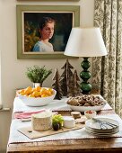 Cheese board and bowls of tangerines and nuts on rustic table