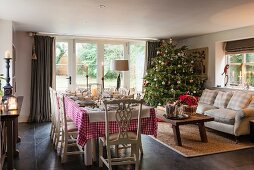 Festlich gedeckter Esstisch mit Weihnachtsbaum in traditionellem Landhaus-Wohnbereich