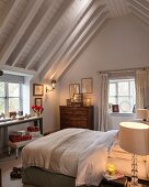 Chest of drawers and wrapped Christmas presents in country-house bedroom