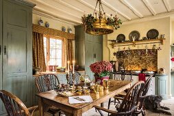 Englische Landhausküche mit altem Holztisch und Stühlen