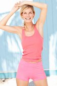 Blonde Frau in rosafarbenem Sporttop und Shorts