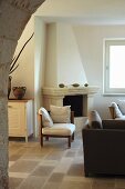 Lounge furniture and beige stone-flagged floor in room with traditional fireplace