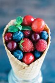 Fresh berries and cherries in an ice cream cone
