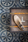 Old chest with a cobbler on patterned cement tiles