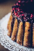 A ring-shaped Bundt cake with berries and chocolate glazing (detail)