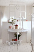 Christmas decorations on semicircular console table against partition