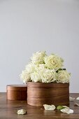 Bunch of white roses on top of dark chip-wood box
