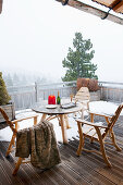 Tisch und Stühle auf dem verschneiten Balkon