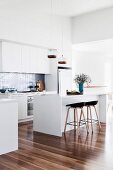Modern white kitchen with shiny wooden floor