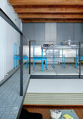 Blue metal chairs round dining table in kitchen on mezzanine