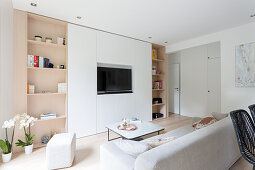 Modern fitted cabinet surrounding TV in white and beige living room