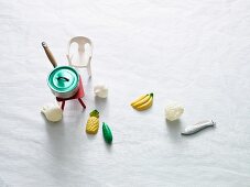 A saucepan, table, chair and decorative food items from a doll's house