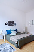 Bedspread and scatter cushions on double bed in simple bedroom