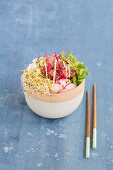 A Poke bowl with tuna, sushi rice, radishes, cucumber slices, and sprouts