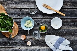 A raw egg with spinach leaves in a glass