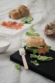 A salmon bagel with cucumber, lettuce and cream cheese