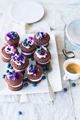 Mini chocolate cakes with blueberry cream and pansies