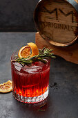 Cocktail mit Rosmarin und getrockneten Orangenscheiben