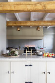 View across counter with base cabinets into country-house kitchen