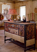 Cabinet covered with pieces of old rug and fringes