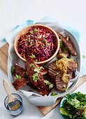 Grillplatte mit Rippchen, Steak und Würstchen serviert mit Coleslaw