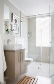 Shower area with glass screen in simple bathroom