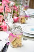 Heart shaped biscuits in a decorative gift jar on a festively laid table