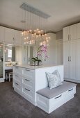 Chest of drawers, custom fitted wardrobes and integrated dressing table in elegant white dressing room