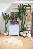 Zimmerpflanzen um ein Schränkchen mit Bild von Frida Kahlo