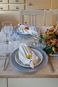 Gedeckter Tisch mit gefalteten Servietten und Blumendeko