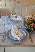 Set table decorated with folded serviettes and flower arrangement