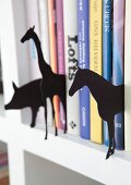 Various animal sihouettes made from black cardboard between books