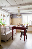 Red wooden table and white bench in Scandinavian kitchen-dining room