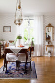 Chairs with ruffled cushions at antique dining table in classic dining room