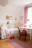 Red upholstered chair and antique desk next to charming in child's bedroom